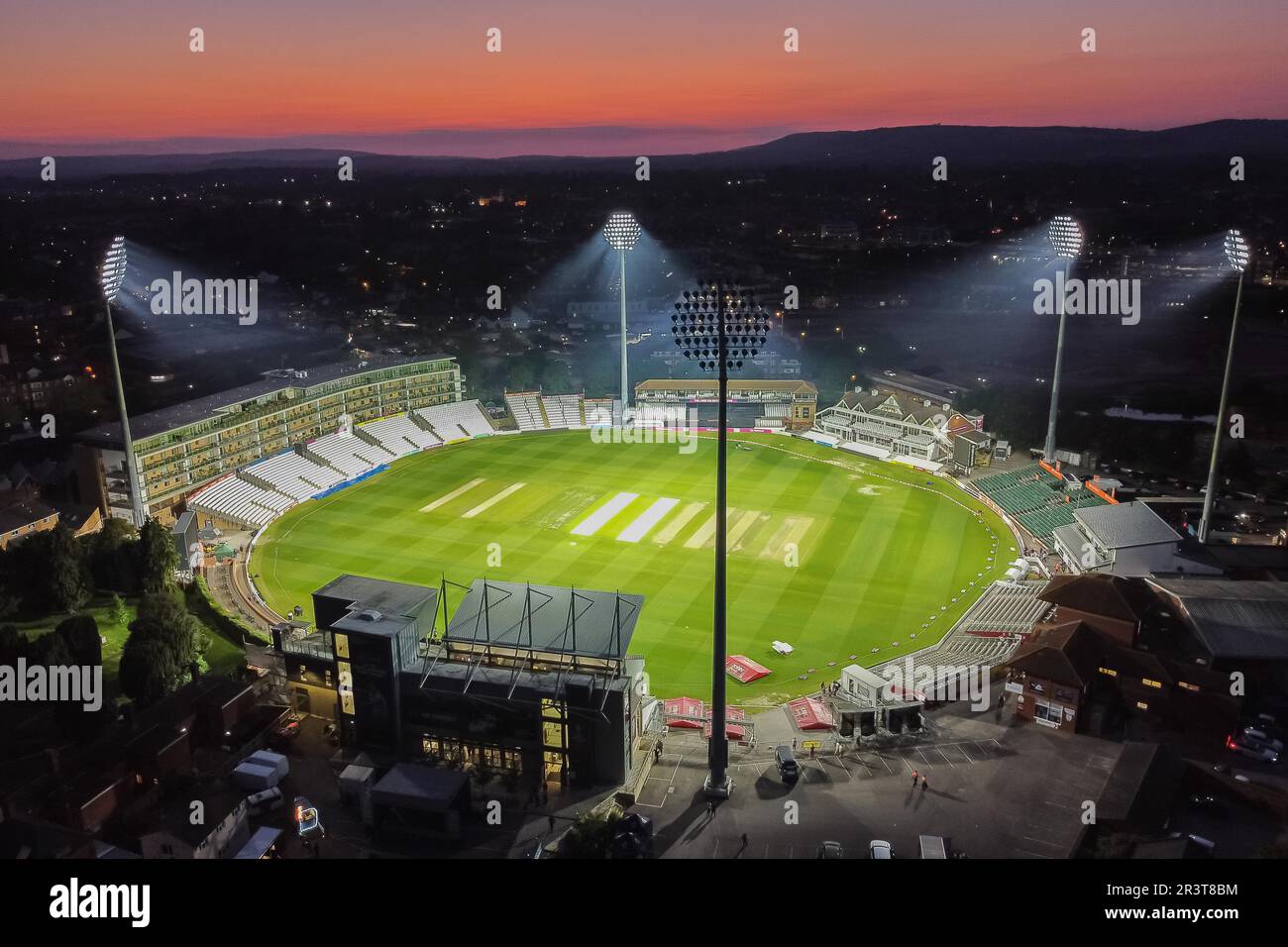 Taunton, Somerset, Großbritannien. 24. Mai 2023 Wetter in Großbritannien. Der Himmel leuchtet orange über dem beleuchteten Cooper Associates County Ground bei Sonnenuntergang am Ende eines heißen, sonnigen Tages nach dem Cricket-Spiel T20 zwischen Somerset und Hampshire. Bildnachweis: Graham Hunt/Alamy Live News Stockfoto