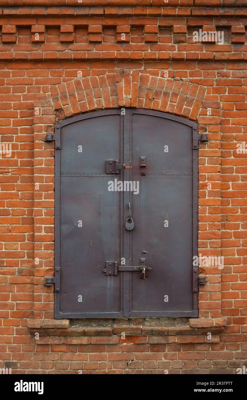 Historischer geschlossener Fensterladen aus Metall in Ziegelmauern Stockfoto