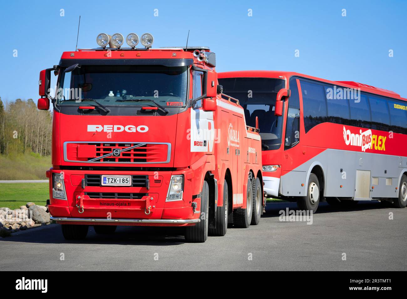 Red Volvo FH Schwerlast-Abschleppwagen bereit zum Abschleppen eines Pannenbusses. Forssa, Finnland. 19. Mai 2023. Stockfoto