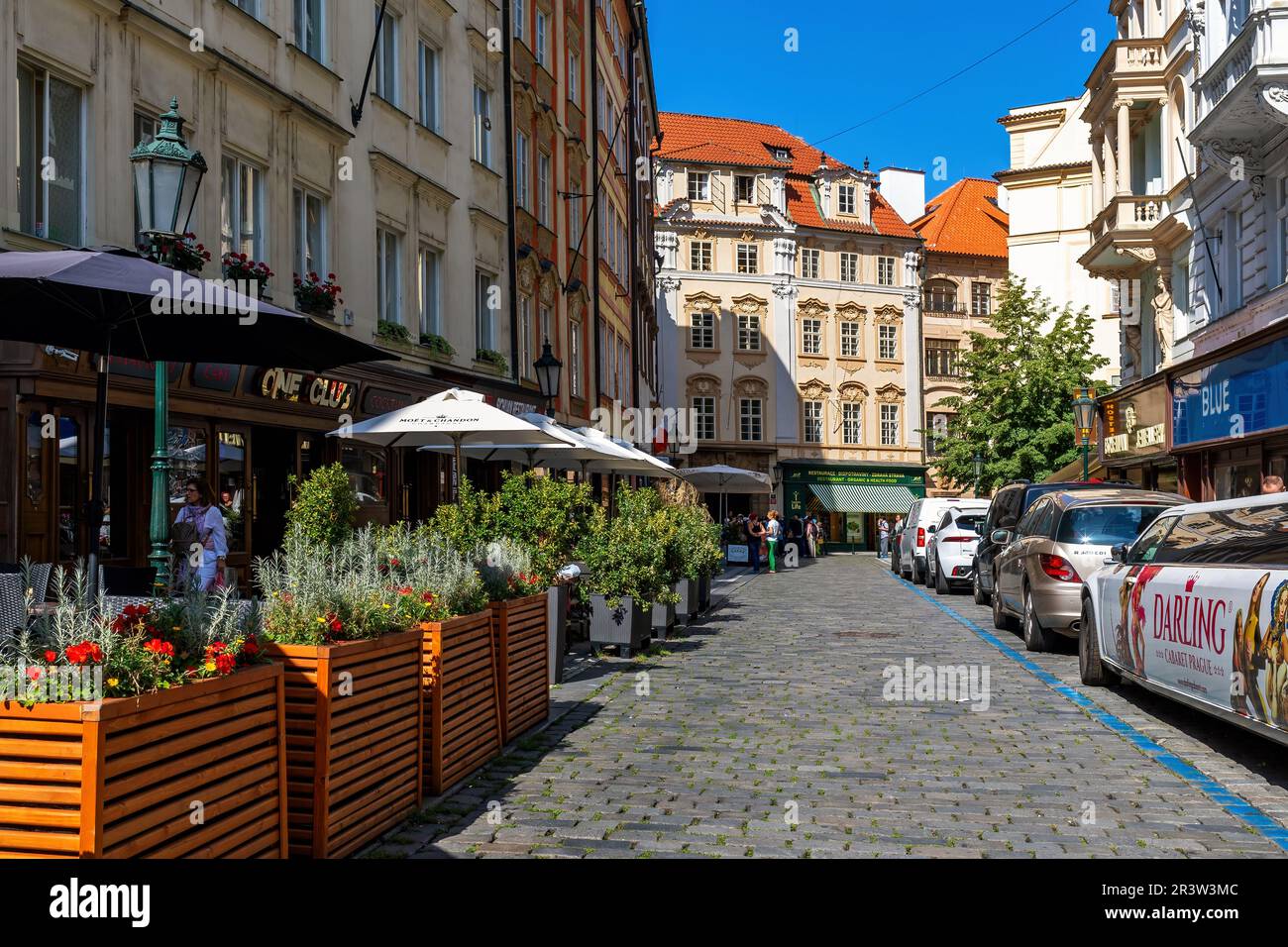 Restaurants im Freien in der Fußgängerzone mit Kopfsteinpflaster inmitten typischer farbenfroher Gebäude in der Altstadt von Prag, Tschechien. Stockfoto
