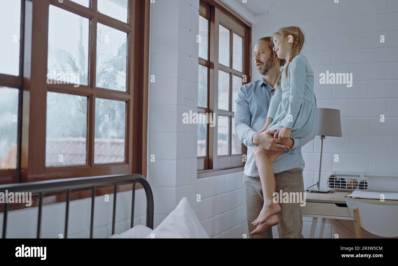 Vater trägt und umarmt Tochter zu Hause. Stockfoto