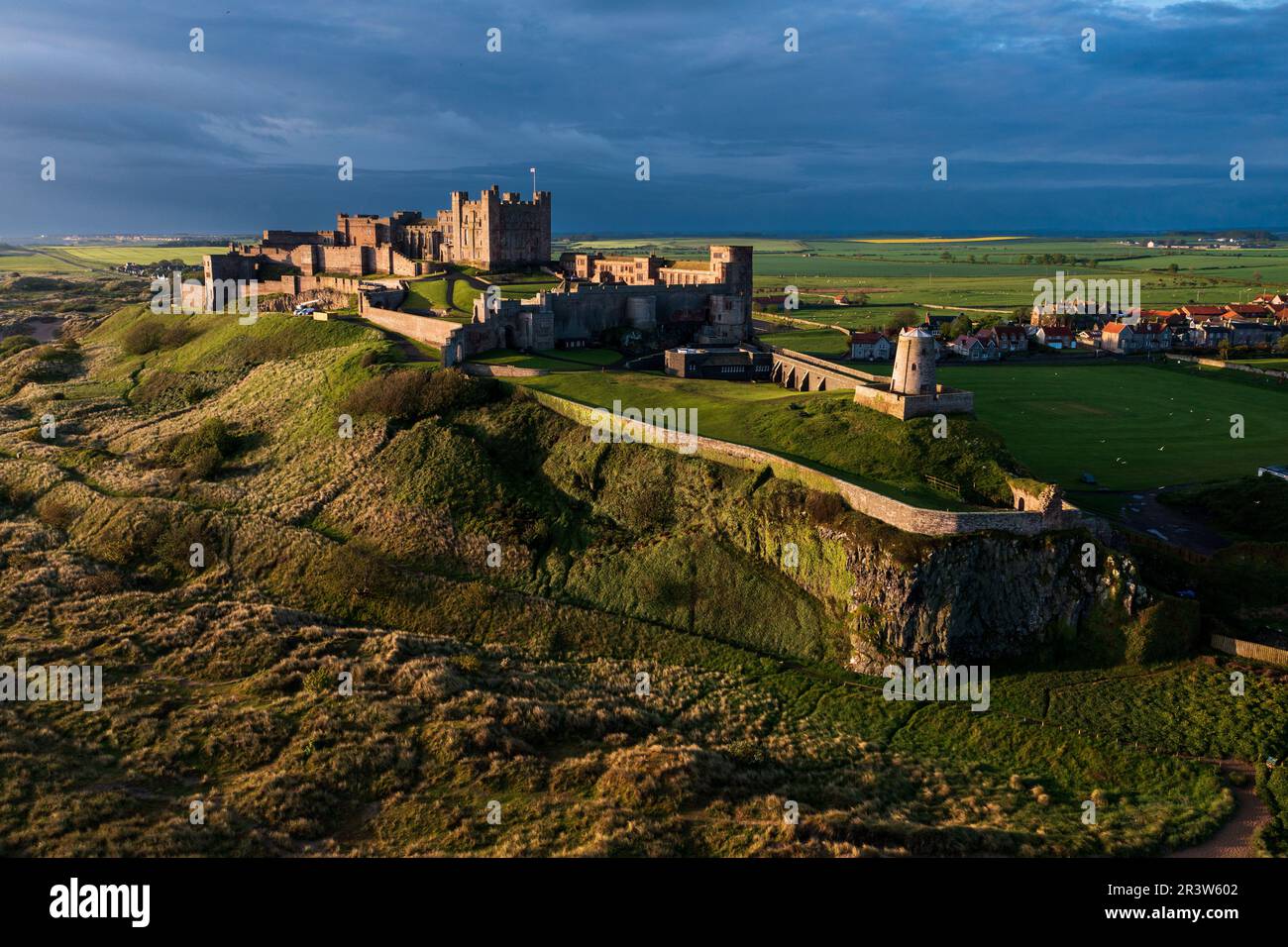 Das berühmte Bamburgh Castle an der Küste von Northumberland aus der Vogelperspektive ist das erste britische Schloss, das in Artillerie gefallen ist. Stockfoto