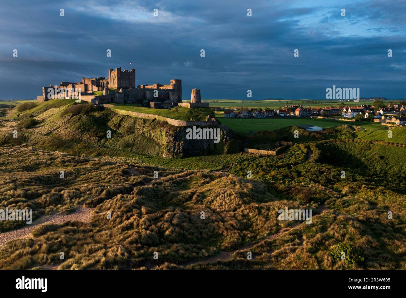 Das berühmte Bamburgh Castle an der Küste von Northumberland aus der Vogelperspektive ist das erste britische Schloss, das in Artillerie gefallen ist. Stockfoto