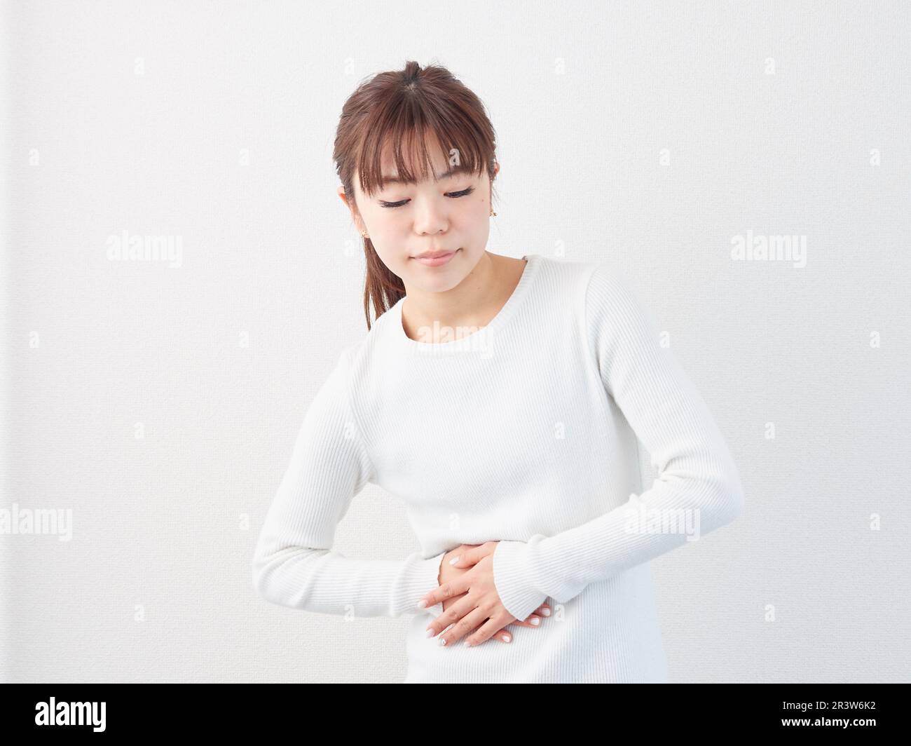 Asiatische Frau mit Bauchschmerzen Stockfoto