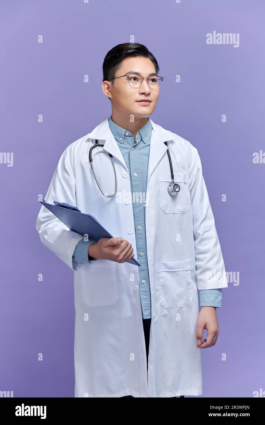 Hüfthohe Porträtsicht des selbstbewussten Arztes in Uniform und Brillenmappe mit ernstem Gesicht Stockfoto