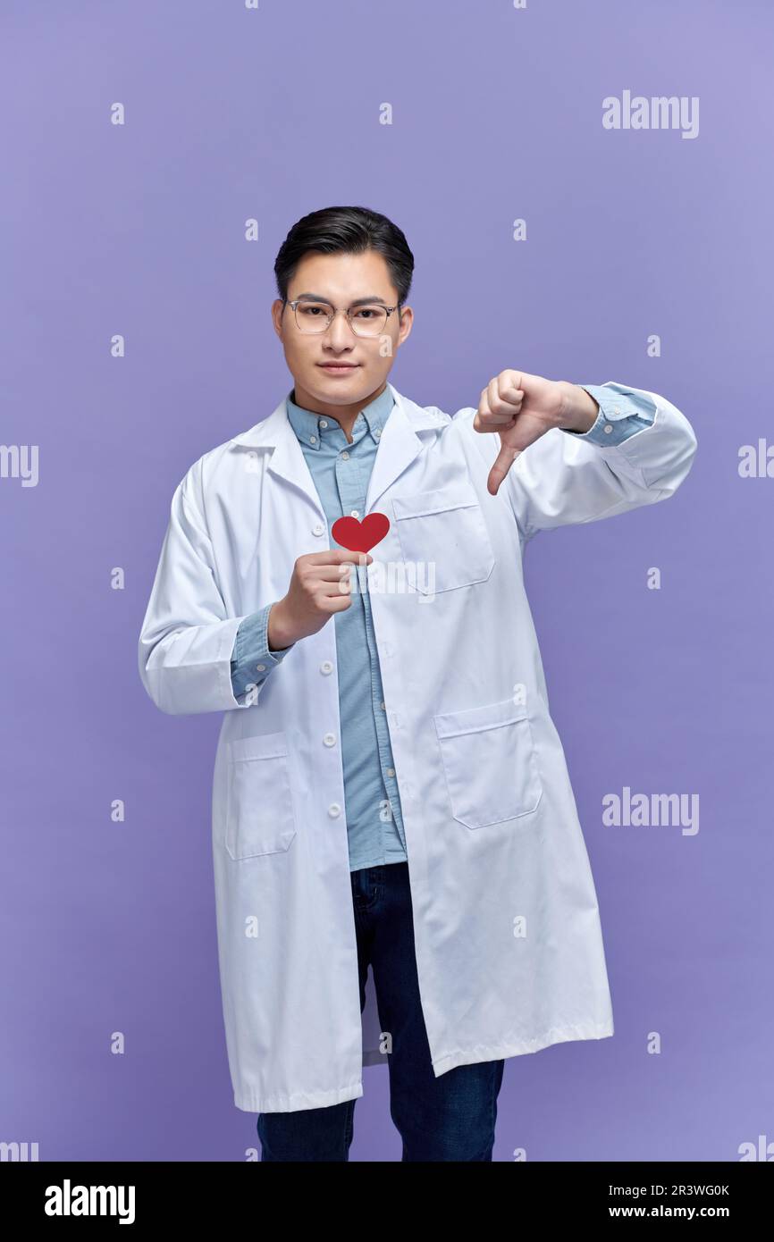 Kardiologe Ärztin Frau mit rotem Herzen, negatives Zeichen mit Daumen nach unten, Abstoßungskonzept Stockfoto