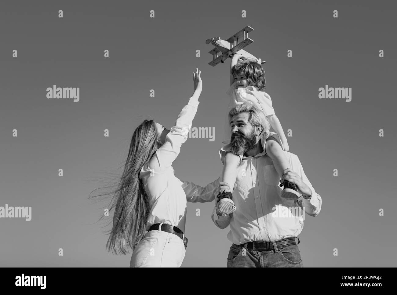 Kindertag. Glückliche Familie Mutter, Vater und Kind mit Spielzeug Flugzeug. Kind träumt Zukunft, Träume und Reisen. Junge Eltern und ihr Kind sind sehr Stockfoto