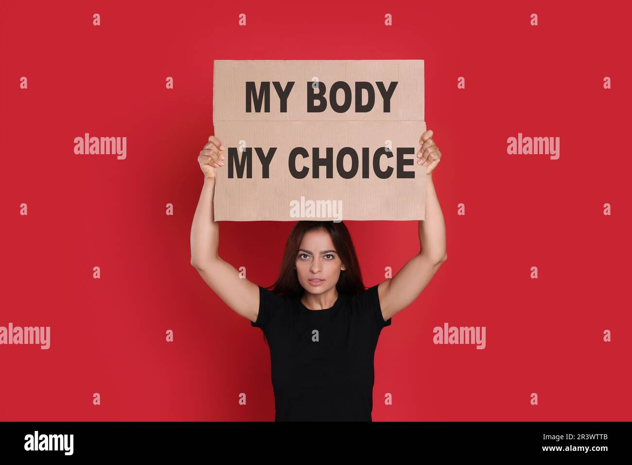 Frau mit Plakat und Phrase My Body My Choice auf rotem Hintergrund. Schwangerschaftsabbruch-Protest Stockfoto