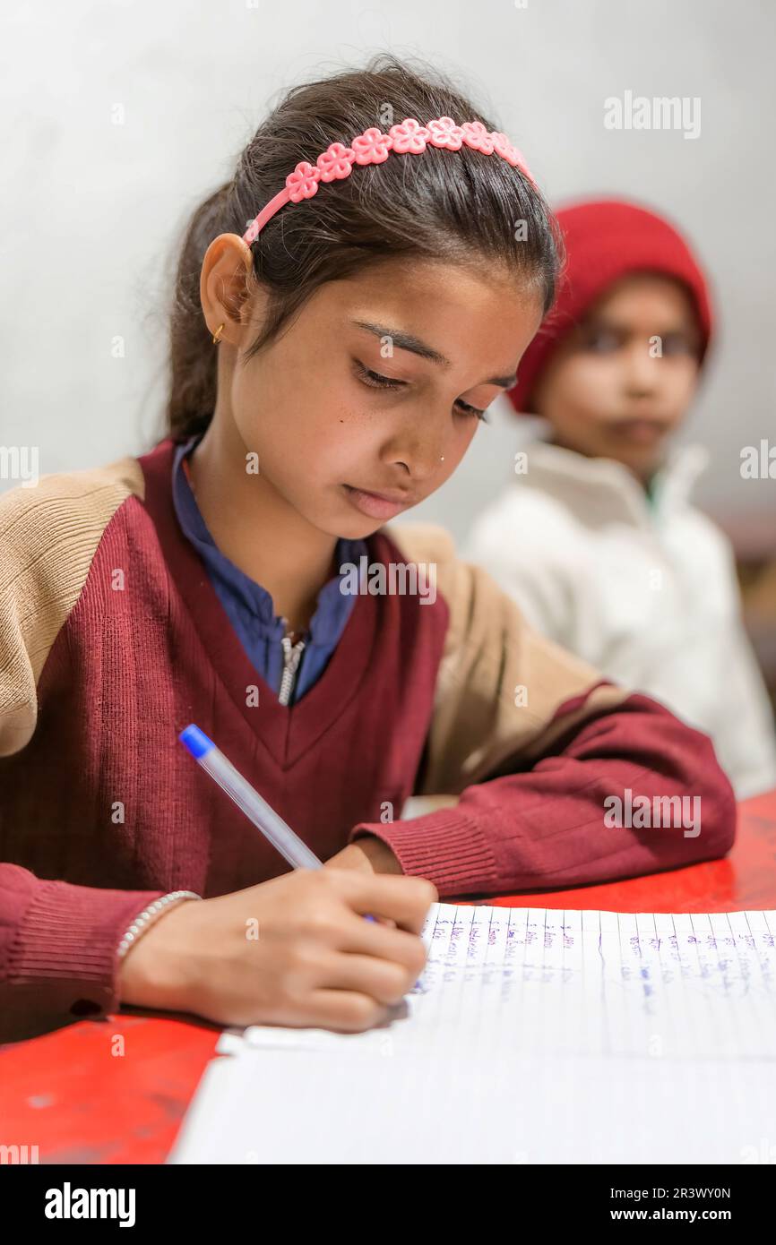 Junge Inderin, die im Klassenzimmer studiert und Notizen macht, Lern- und Bildungskonzept, Grundschule in Indien. Stockfoto