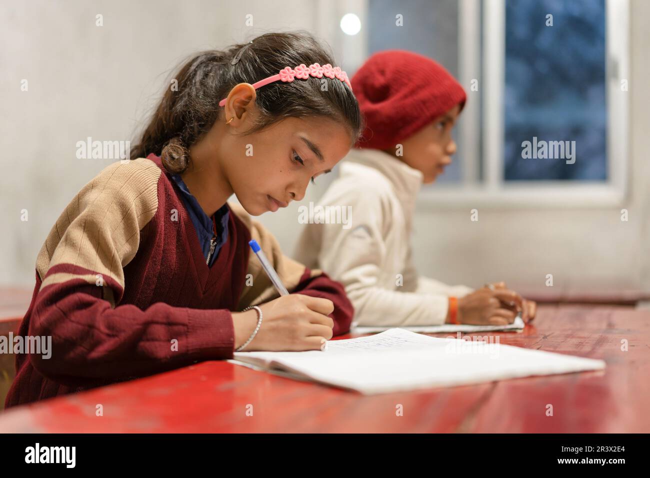 Kleine indische Kinder, die im Klassenzimmer lernen und Notizen machen, Lern- und Bildungskonzept, Grundschule in Indien. Stockfoto