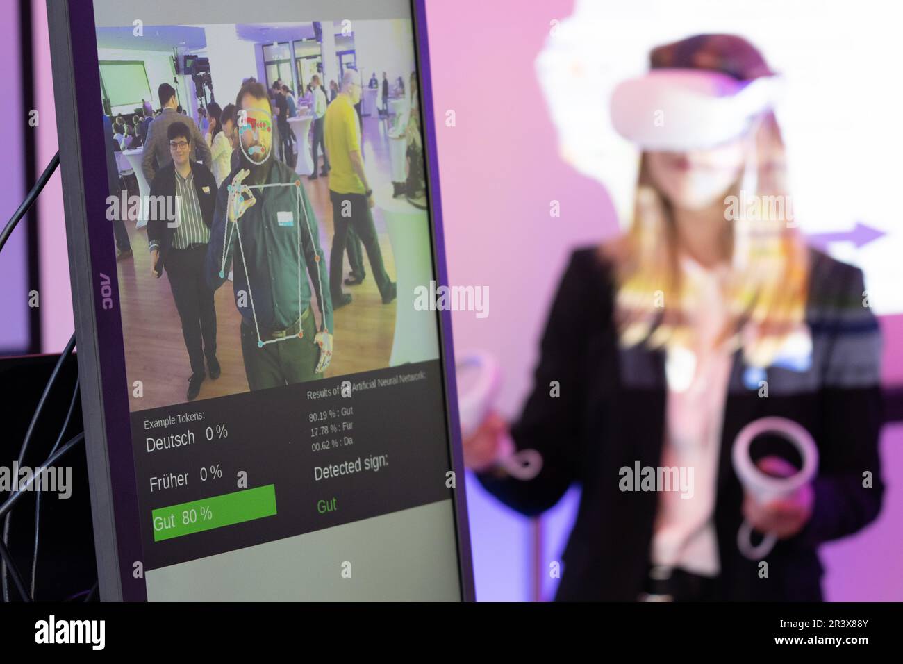 Dresden, Deutschland. 25. Mai 2023. Dominik Wetzel, westsächsische Universität für angewandte Wissenschaften Zwickau, steht im Rahmen des Kongresses der sächsischen Landesregierung zum Thema "wo stehen wir zum Thema künstliche Intelligenz?" vor einem interaktiven Lernsystem für Gebärdendolmetscher. Zu den Themen der Veranstaltung gehören der Einsatz von KI in Forschung, Wirtschaft, Bildung, Verbraucherschutz und gesetzliche Vorschriften. Kredit: Sebastian Kahnert/dpa/Alamy Live News Stockfoto