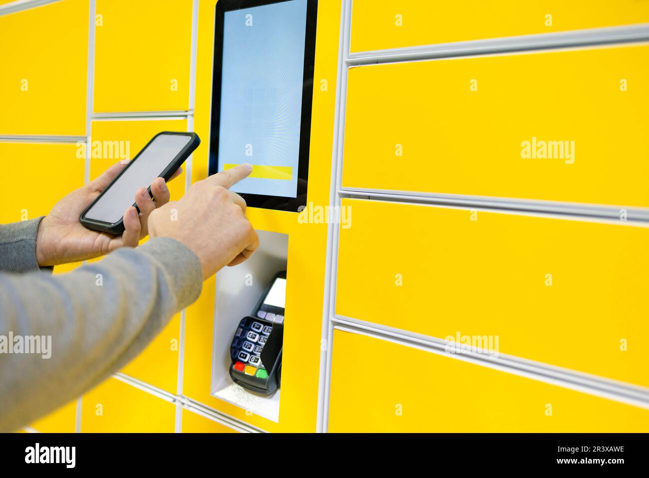 Nahaufnahme eines Mannes, der Post von einem automatisierten Self-Service-Postautomaten abholt Stockfoto