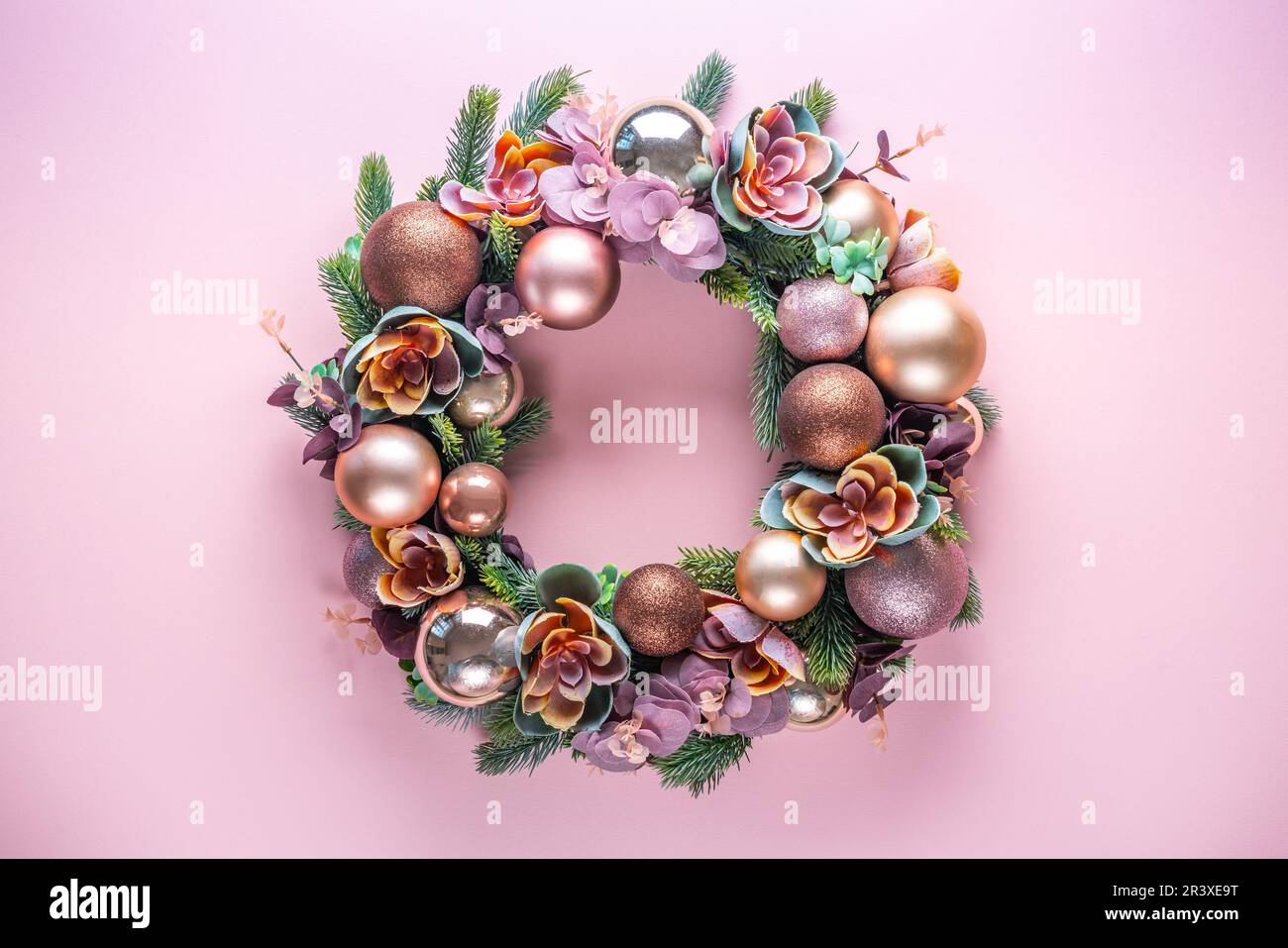 Wunderschöne ungewöhnliche Weihnachtskranzdekoration auf pinkfarbenem Hintergrund. Flach verlegt Stockfoto
