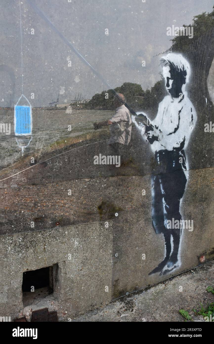 Angeln von Jungen: Street Art im Banksy-Stil auf einer Pillbox-Festung aus dem 2. Weltkrieg in Harwich, Essex, Großbritannien Stockfoto