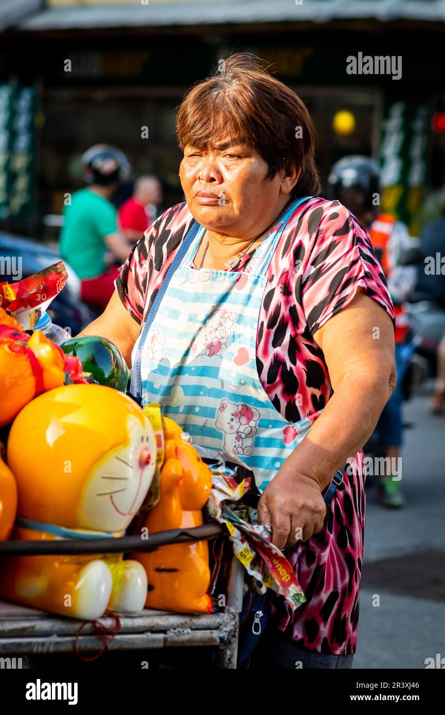 Eine thailändische Dame, die Spielzeuge von einem Wagen verkauft, fährt durch Pattaya Thailand. Stockfoto