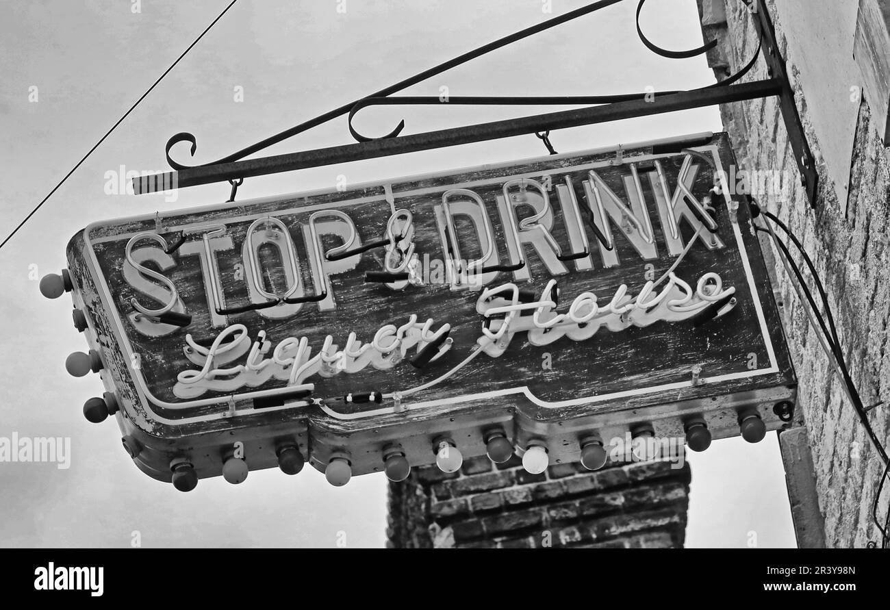 Elektrisches Schild in antikem Neon für das Stop & Drink Liquor House, amerikanisches Schwarzweiß-Schild im Stil der 1950er Jahre Stockfoto