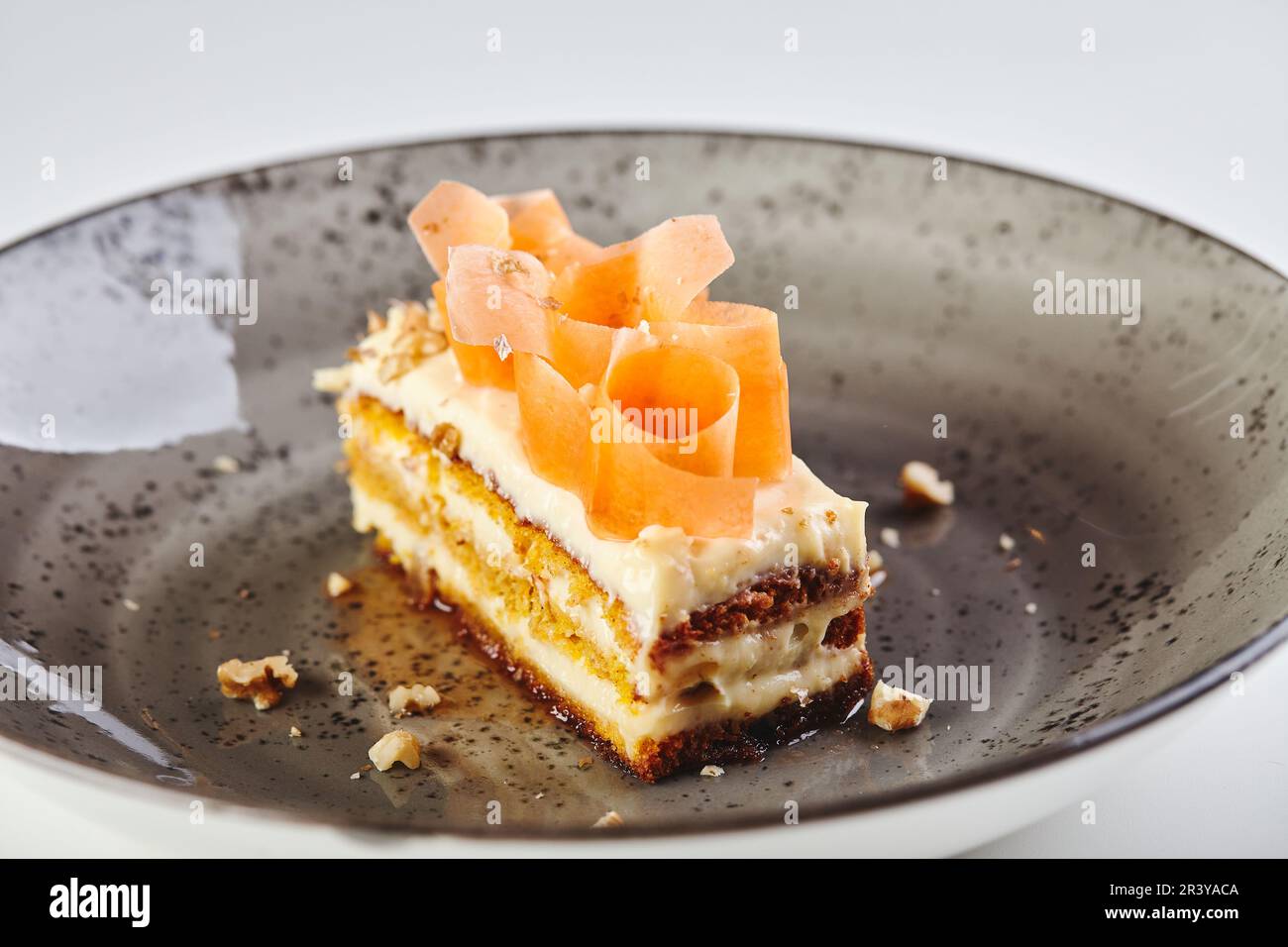 Nahaufnahme eines Stücks Karottenkuchen auf dem Teller auf weißem Hintergrund Stockfoto
