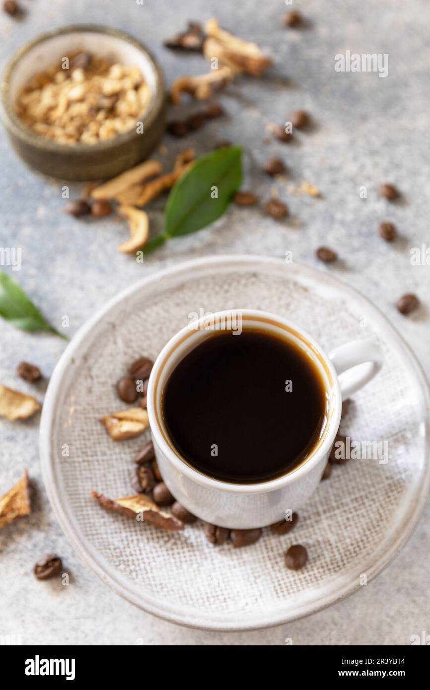 Gesundes organisches, energiegeladenes Adaptogen, trendiges Getränk. Pilzkaffee in einer Tasse mit Kaffeebohnen. Stockfoto