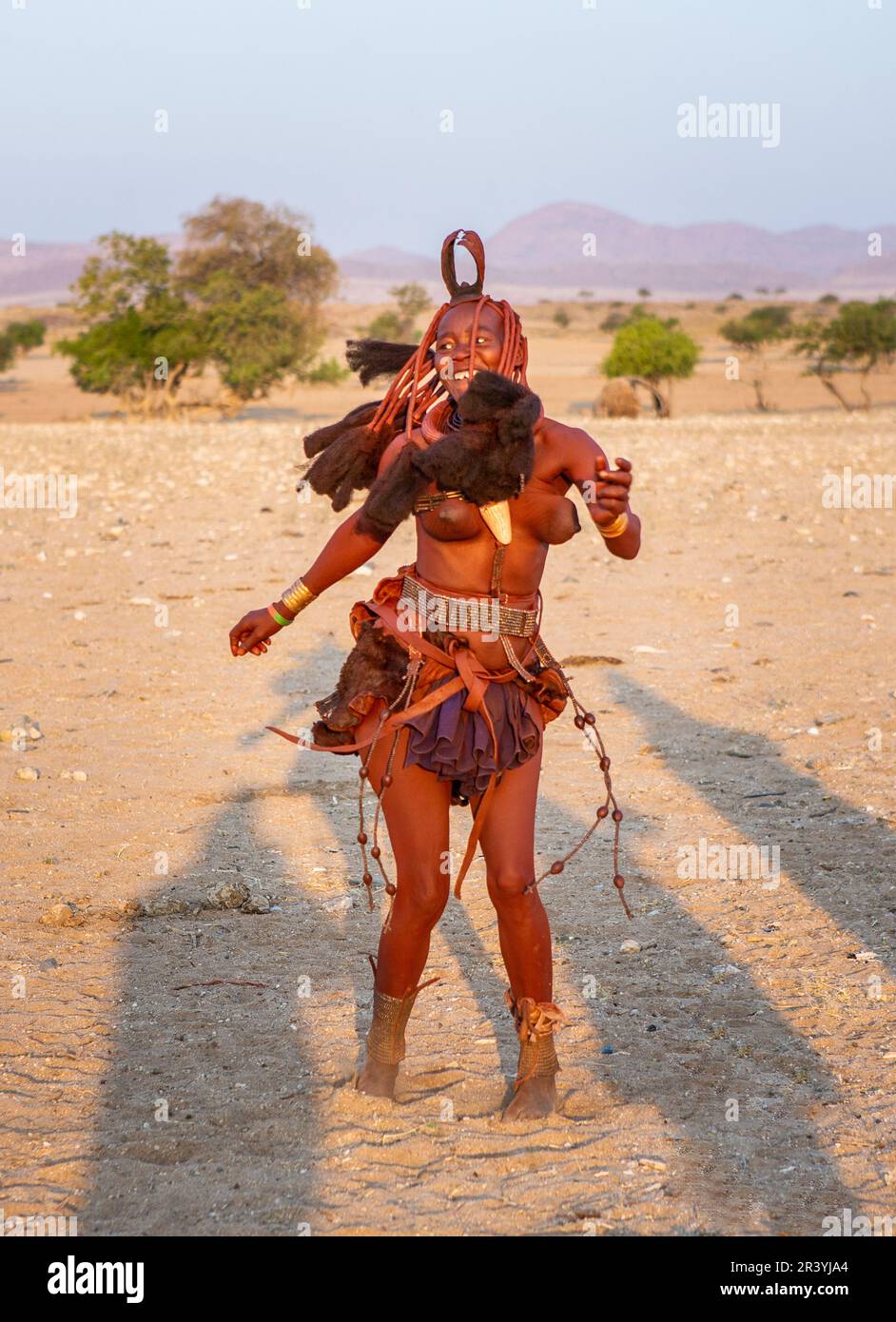 Himba-Frau tanzt auf dem Sand Stockfoto