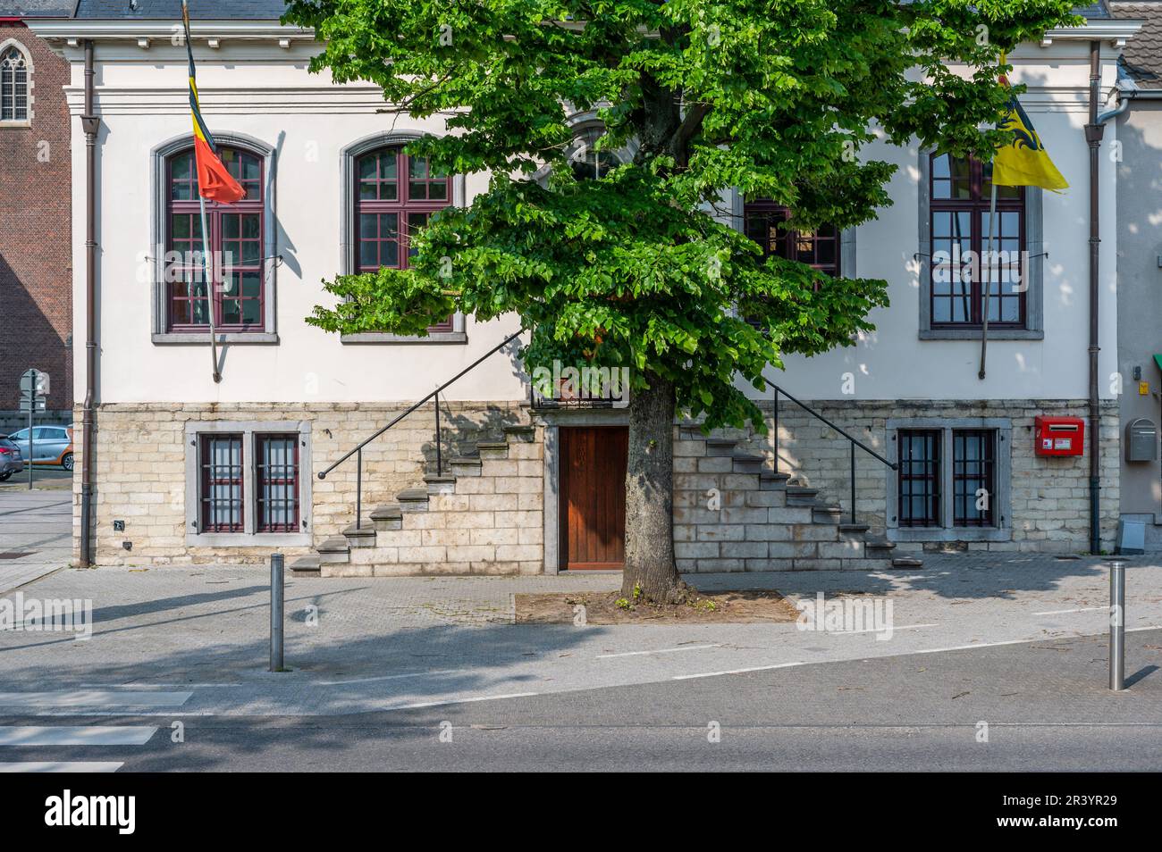 Sint-Gillis-Waas, Ostflämische Region, Belgien - 21. Mai 2023 - Historisches Gebäude des Rathauses mit Flaggen und Bäumen Stockfoto