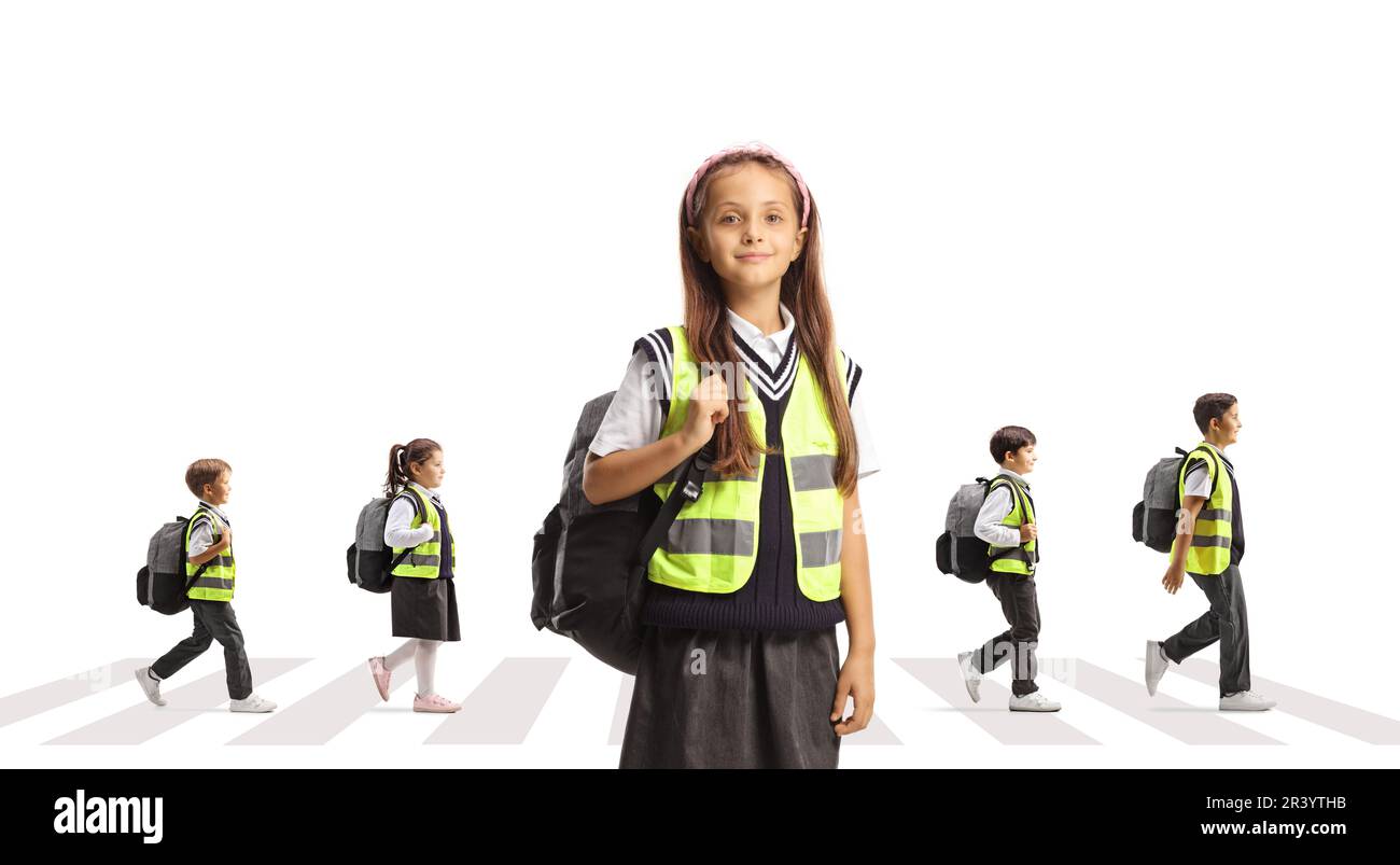 Mädchen in Sicherheitsweste posieren und andere Kinder überqueren eine Straße an einem Fußgängerübergang isoliert auf weißem Hintergrund Stockfoto