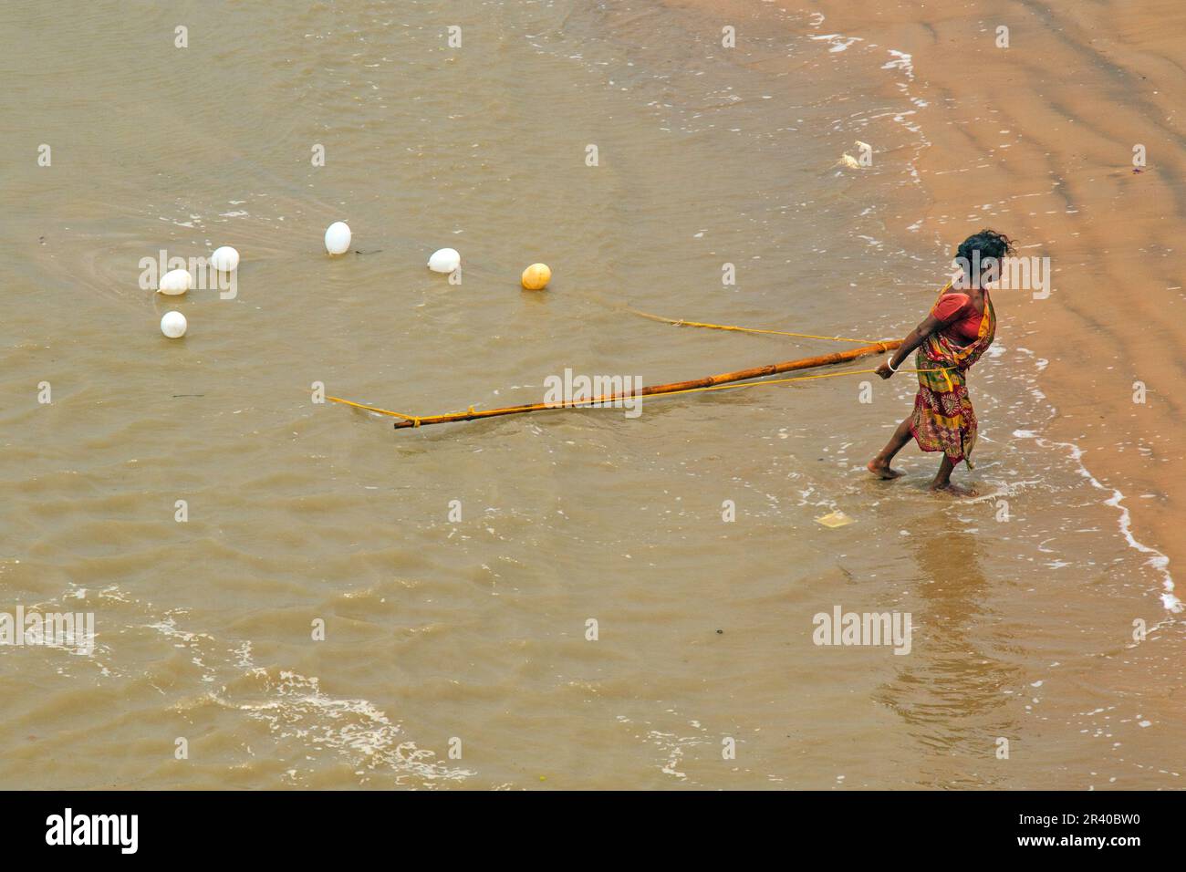 Fischer und Frauen arbeiten daran, am heißen, sonnigen Morgen Garnelen im Fluss zu fangen. Stockfoto