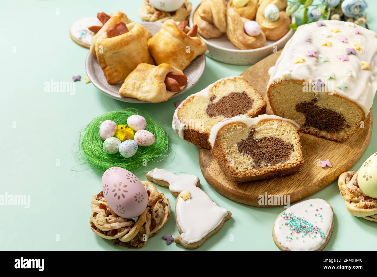 Festliches Abendessen, Osterbrunch. Frohes Osterferienessen Backen von Blätterteig und Cupcake mit Osterhasen auf pastellgrünem Backgr Stockfoto