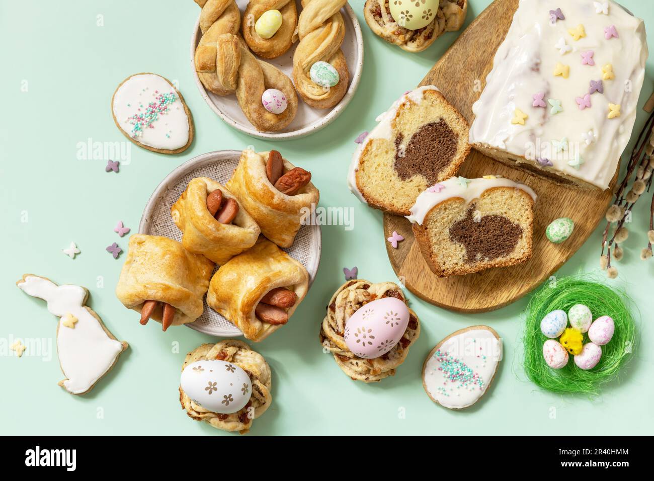 Festliches Abendessen, Osterbrunch. Frohes Osterferienessen Backen von Blätterteig und Cupcake mit Osterhasen auf pastellgrünem Backgr Stockfoto