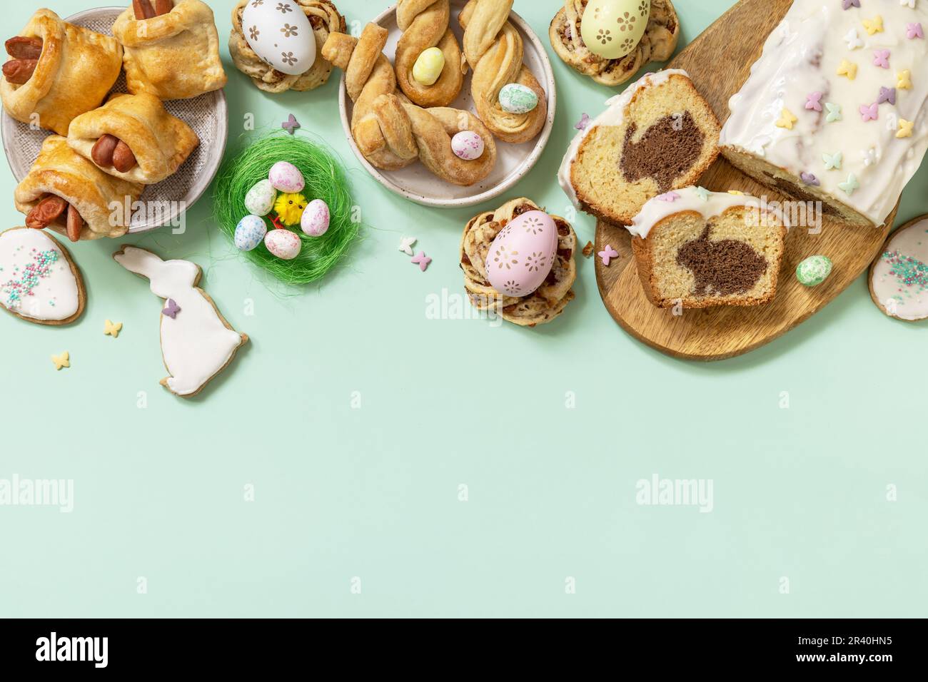 Festliches Abendessen, Osterbrunch. Frohes Osterferienessen Backen von Blätterteig und Cupcake mit Osterhasen auf pastellgrünem Backgr Stockfoto