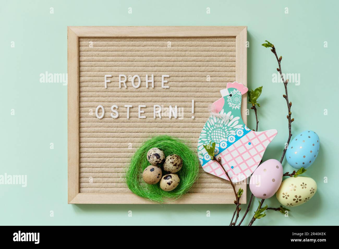 Brieftafel mit Frohe Ostern: Frohe Ostern in deutscher Begrüßung, Ostereier und grüne Zweige auf grünem Hintergrund. Ansicht von Stockfoto