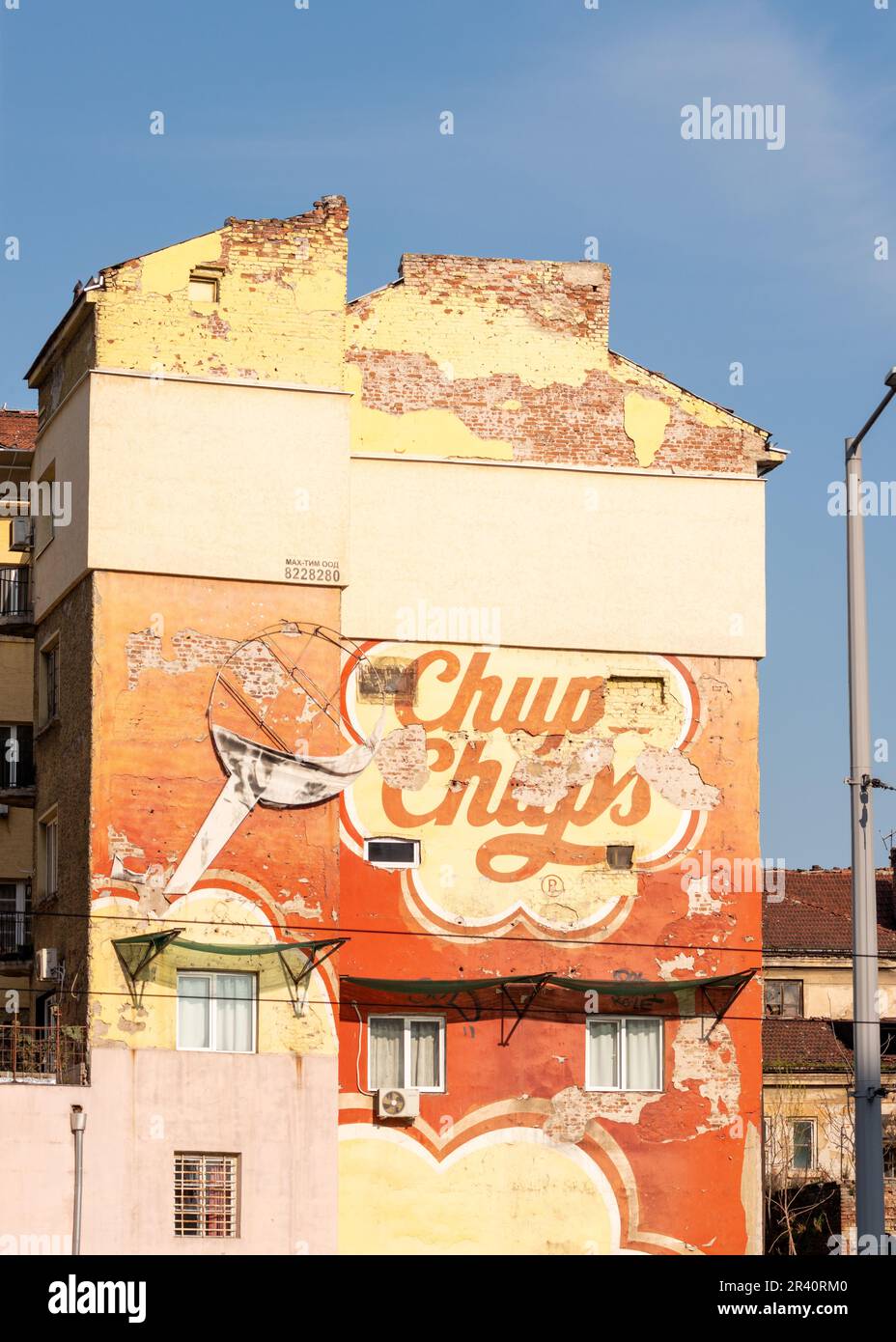 Street Art Wandbild verblasste alte Chupa Chups Wandwerbung auf verwitterten Fassadenwänden von Wohngebäuden in Sofia, Bulgarien, Osteuropa, Balkan, EU Stockfoto