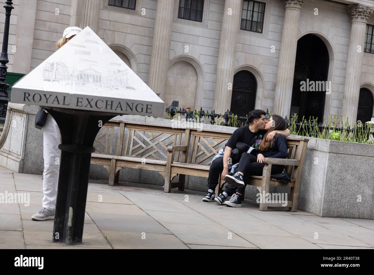 Ein Paar, das einen intimen Moment genießt, während es vor der Royal Exchange im Herzen der City of London, England, Großbritannien saß Stockfoto