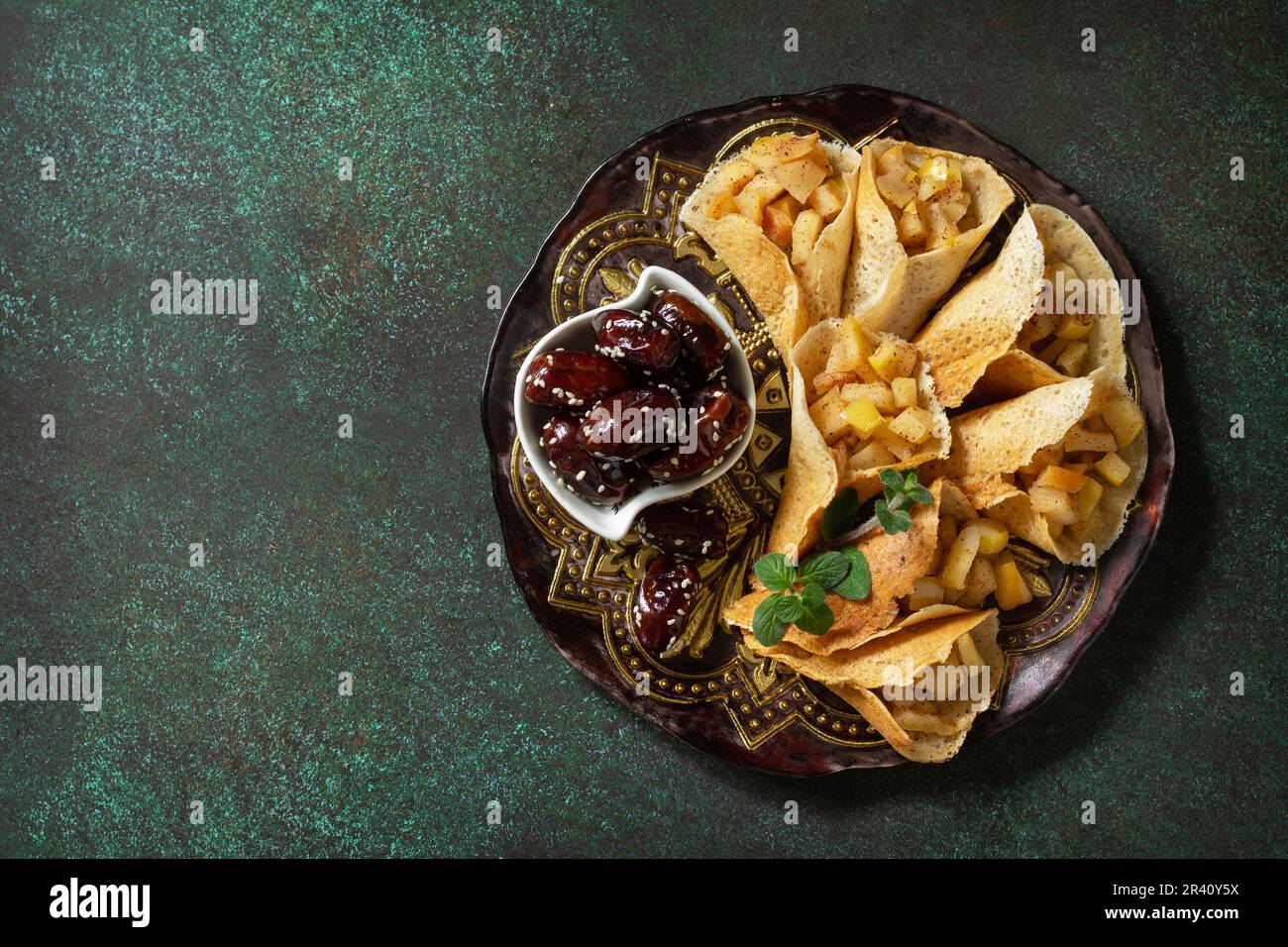 Ramadan Karäem festlich, Fasten, Halal-Essen. Ramadan-Menü, arabischer Pfannkuchen-Katayef (katajew, Katajef) mit Apfelfüllung und cin Stockfoto