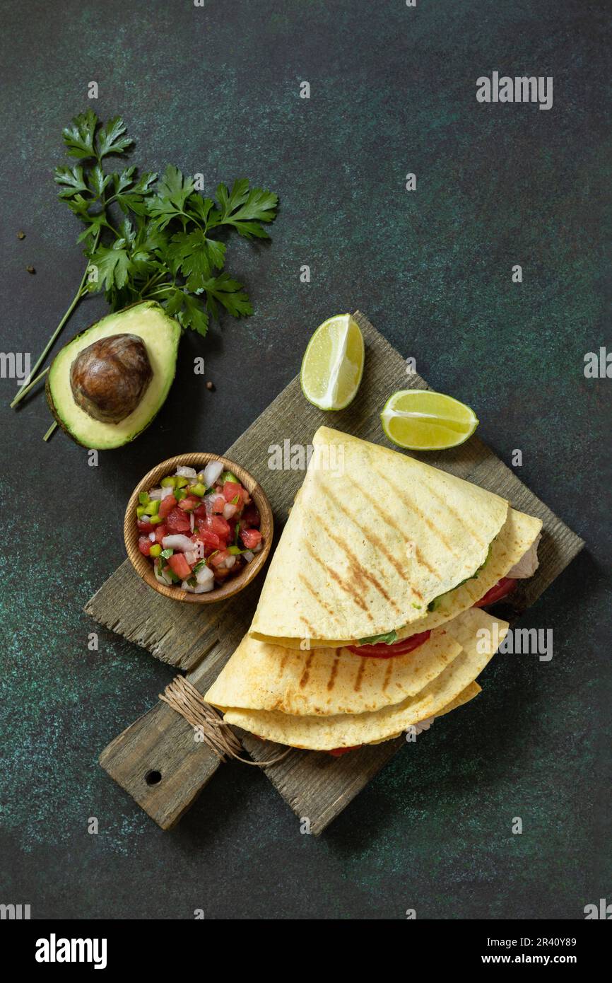 Gesundes Mittagessen. Tortilla-Sandwich, mexikanische Wraps mit gegrilltem Hühnerfilet und Avocado, serviert mit Guacamole. Blick von oben Stockfoto