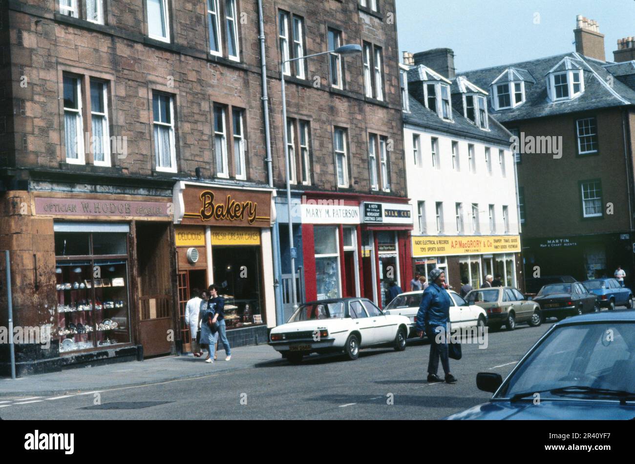 Campbeltown, Schottland, Großbritannien - Juli 1983: Kreuzung von Longrow und Main Street, klassische Filmszene mit Geschäften Stockfoto Campbeltown, Schottland, Großbritannien - Juli 1983: Kreuzung von Longrow und Main Street, klassische Filmszene mit Geschäften Stockfoto