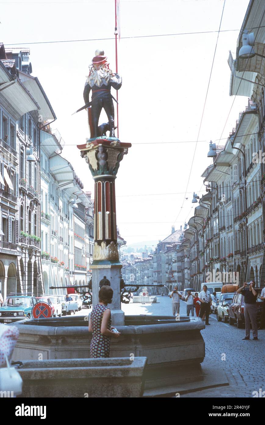 Bern, Schweiz - August 1972: Rückansicht des Zähringer Brunnens mit Blick auf die Straße mit 1970er Touristen, klassischer Diashow. Stockfoto Bern, Schweiz - August 1972: Rückansicht des Zähringer Brunnens mit Blick auf die Straße mit 1970er Touristen, klassischer Diashow. Stockfoto