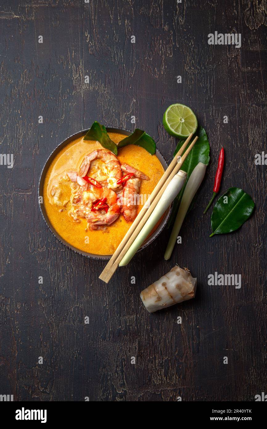 Garnelen Tom Yam Kung in grauen Schale mit thailändischen Gewürzen auf authentisch Fach oben, Holz- Hintergrund. Stockfoto