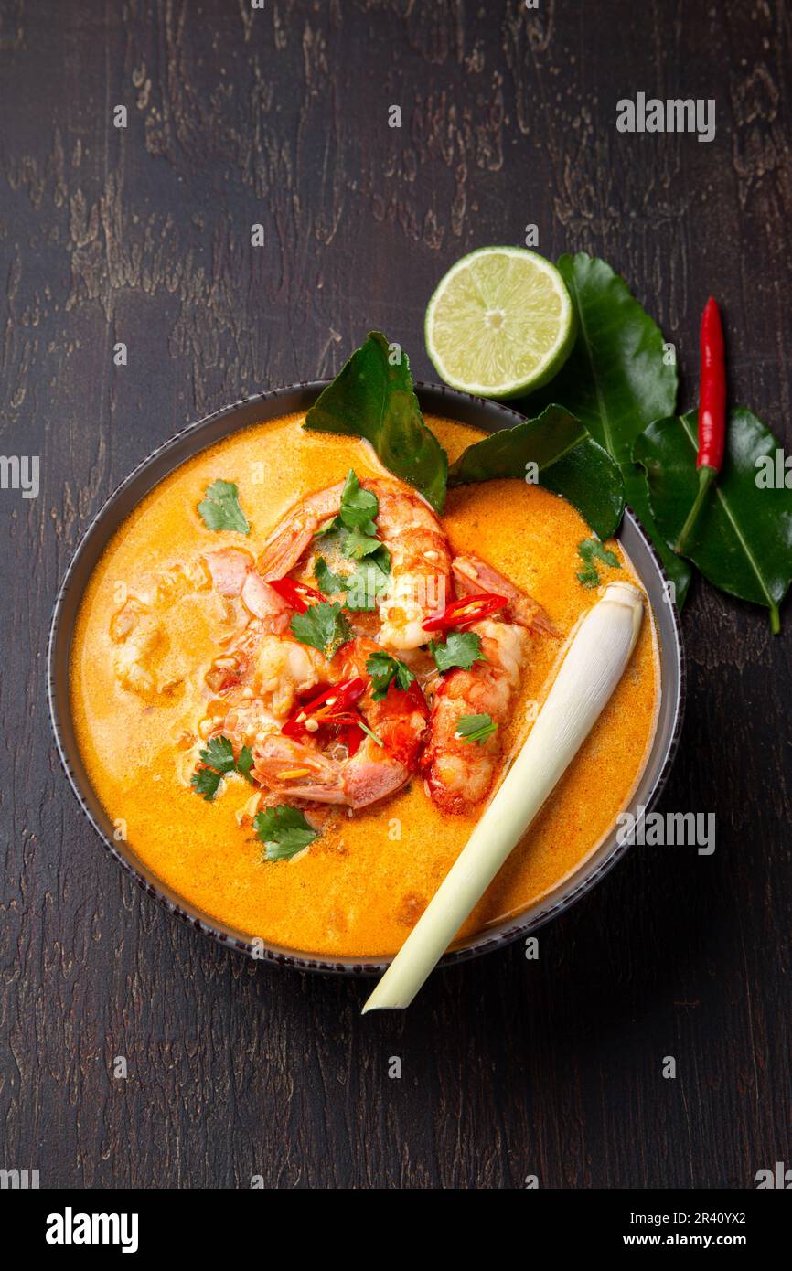 Garnelen Tom Yam Kung in grauen Schale mit thailändischen Gewürzen auf authentisch Fach oben, Holz- Hintergrund. Stockfoto