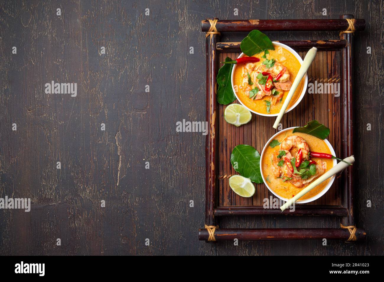 Garnelen Tom Yam Kung in grauen Schale mit thailändischen Gewürzen auf authentisch Fach oben, Holz- Hintergrund. Stockfoto
