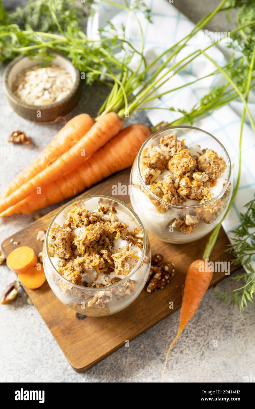 Veganes glutenfreies Backen. Karottenkuchen mit Walnüssen und Zimt in einem Glas auf hellem Hintergrund. Gesundes Dessert. Stockfoto