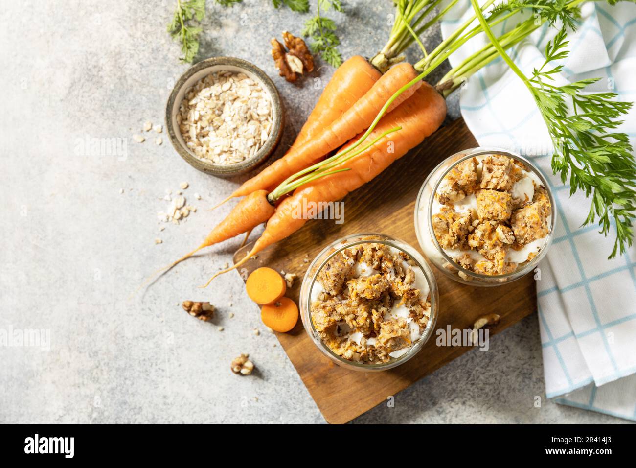 Veganes glutenfreies Backen. Karottenkuchen mit Walnüssen und Zimt in einem Glas auf hellem Hintergrund. Gesundes Dessert. Blick von ABO Stockfoto