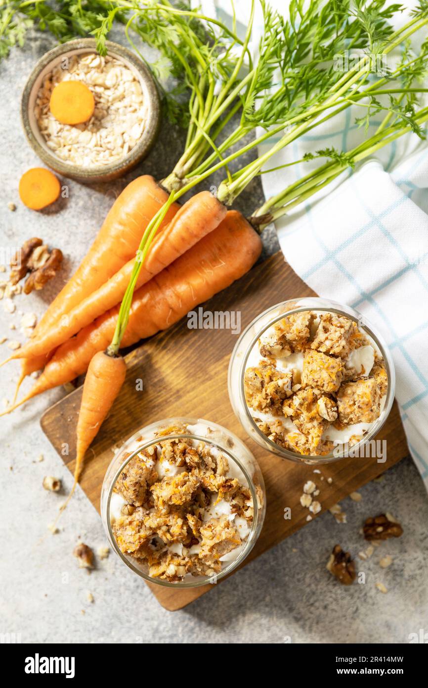 Veganes glutenfreies Backen. Karottenkuchen mit Walnüssen und Zimt in einem Glas auf hellem Hintergrund. Gesundes Dessert. Blick von ABO Stockfoto