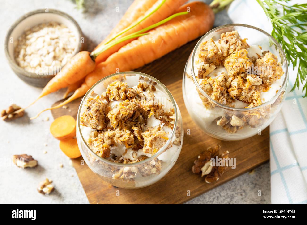 Veganes glutenfreies Backen. Karottenkuchen mit Walnüssen und Zimt in einem Glas auf hellem Hintergrund. Gesundes Dessert. Stockfoto