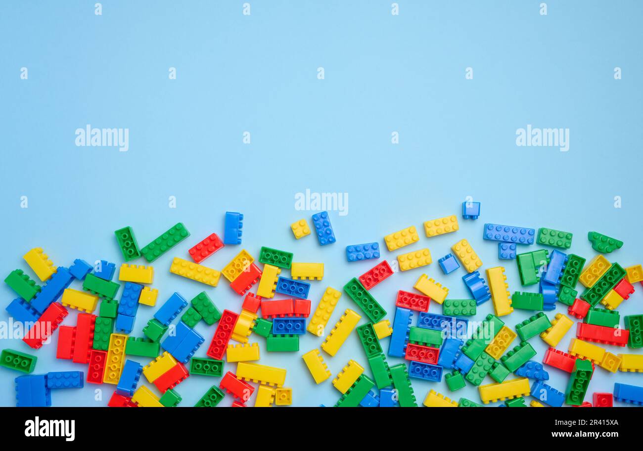 Mehrfarbige Kunststoffwürfel eines Kinderdesigners auf blauem Hintergrund, Draufsicht Stockfoto