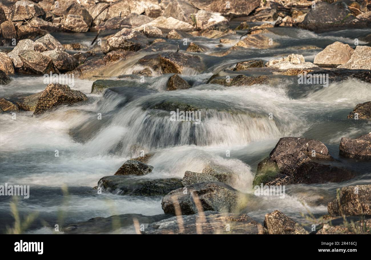 Fluss fließt über Felsen Kaskade an sonnigen Tagen, Nahaufnahme - Langzeitaufnahme Foto Stockfoto