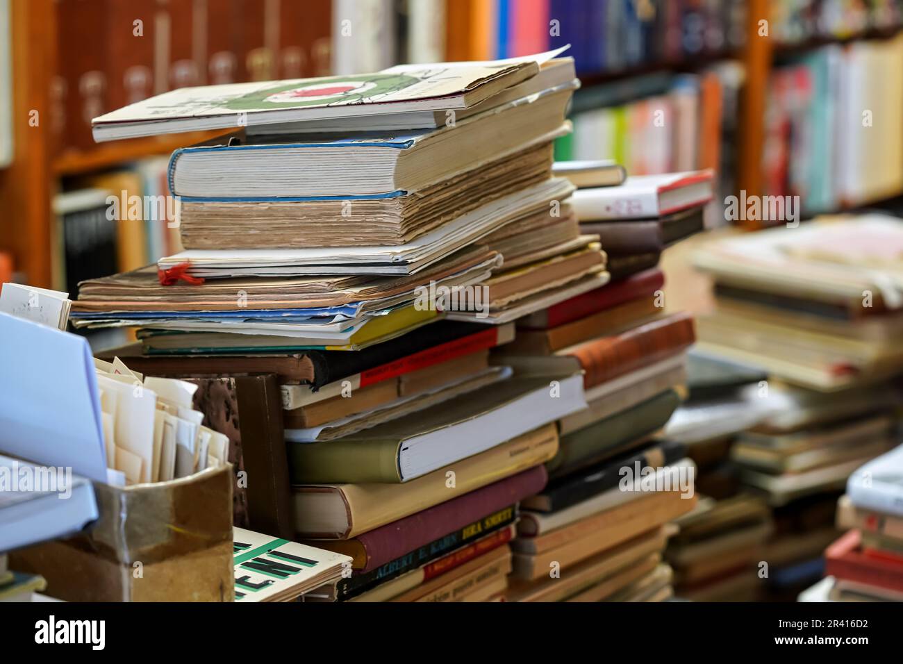 Stapel von vielen alten gebrauchten Büchern, die im örtlichen Antiquariat ausgestellt sind Stockfoto