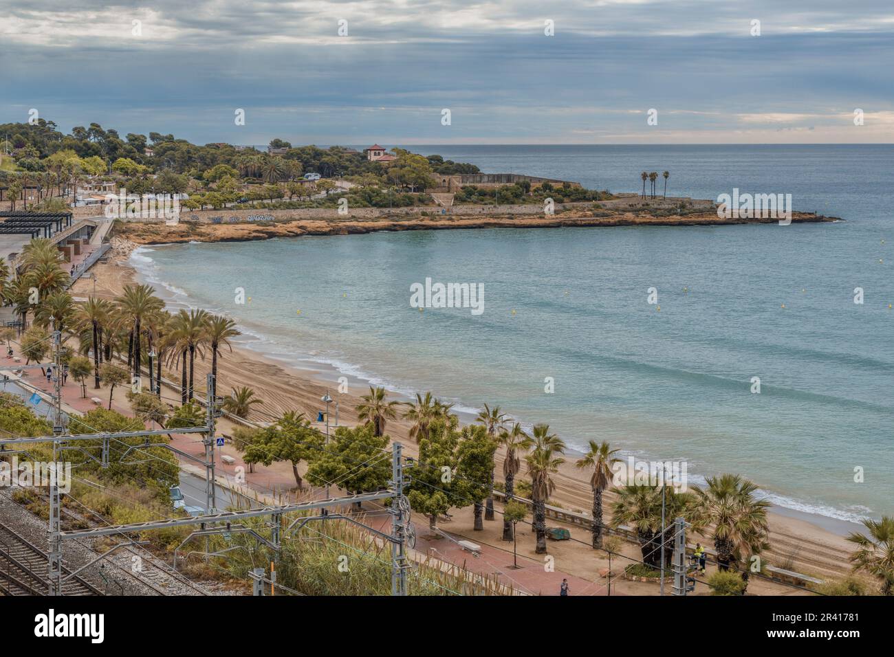 Platja del Miracle-Playa El Milagro die Promenade, die Straße und die Bahngleise mit dem Hafen der Stadt Tarragona in der Gemeinde Katalonien. Stockfoto