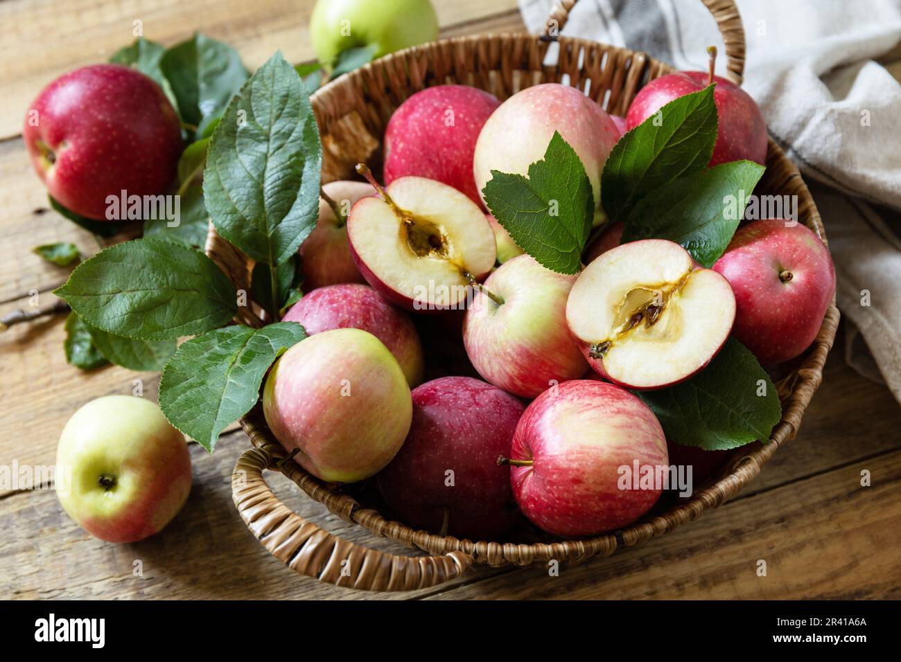 Hintergrund Herbsternte. Bio-Früchte. Bauernmarkt. Korb reifer Äpfel auf einem rustikalen Holztisch. Stockfoto