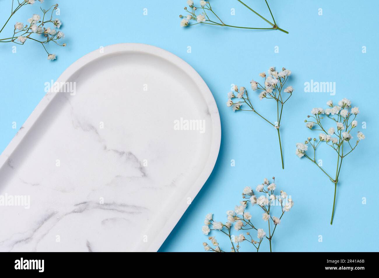 Leere weiße ovale Marmorplatte auf blauem Hintergrund, Draufsicht Stockfoto