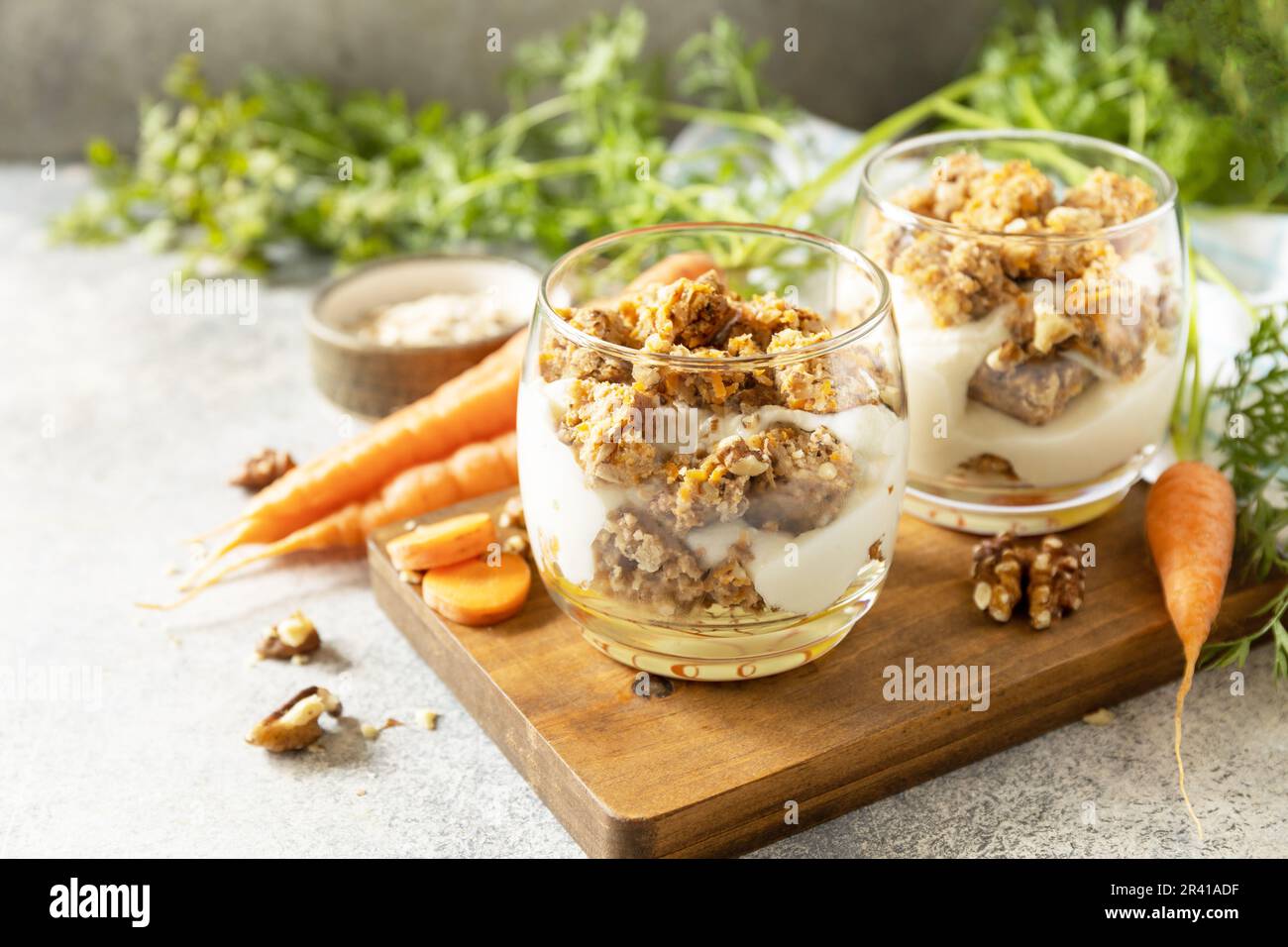 Veganes glutenfreies Backen. Karottenkuchen mit Walnüssen und Zimt in einem Glas auf hellem Hintergrund. Gesundes Dessert. Speicherplatz kopieren. Stockfoto